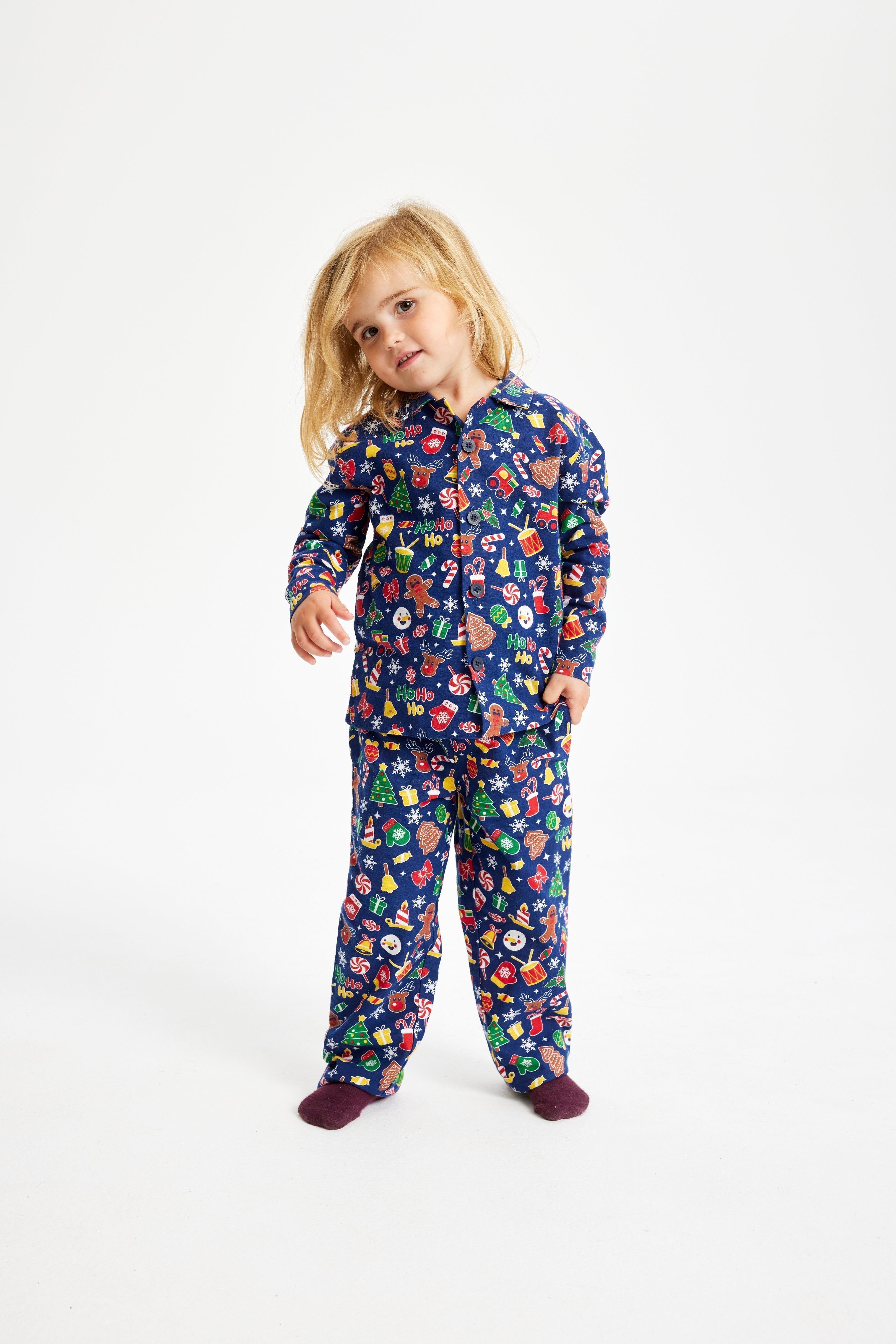Un enfant portant un pyjama de Noël bleu avec un imprimé de Noël.